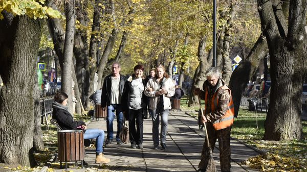 Дворник подметает тротуар в Симферополе. Осень
