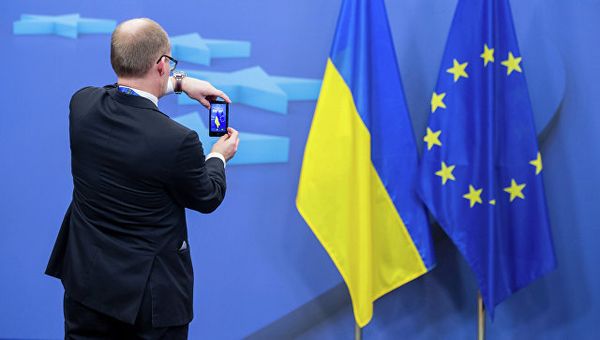 Человек фотографирует флаги Украины и Евросоюза Человек фотографирует флаги Украины и Евросоюза