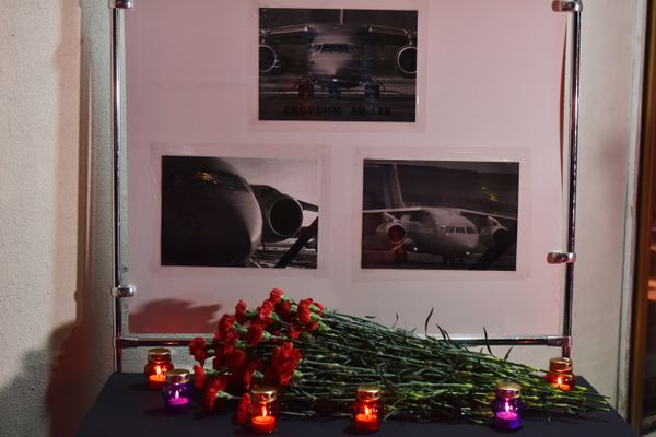Стенд с фото самолета Ан-148, установленный в Симферополе в память о жертвах авиакатастрофы в Подмосковье