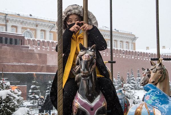 Туристка из Китая на карусели на Красной площади