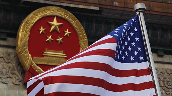 Флаг США на фоне эмблемы Китая в Пекине. Архивное фото
