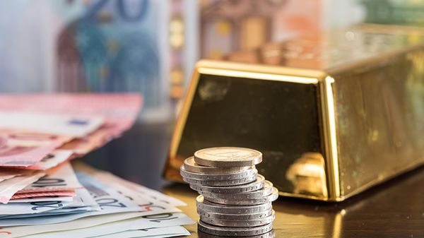 Слиток золота, монеты и банкноты евро