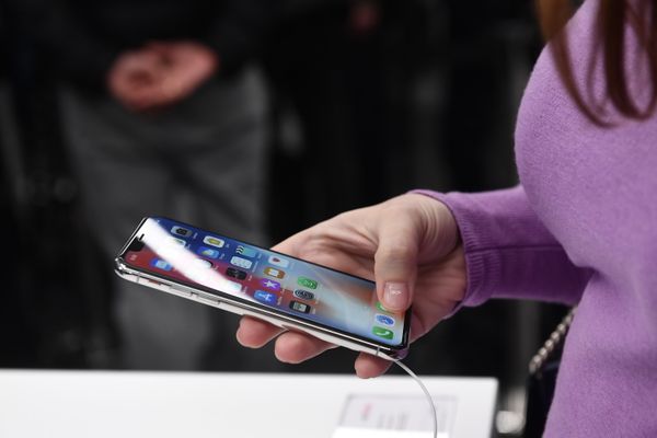 Покупательница рассматривает новый смартфон iPhone X в магазине re:Store в Москве