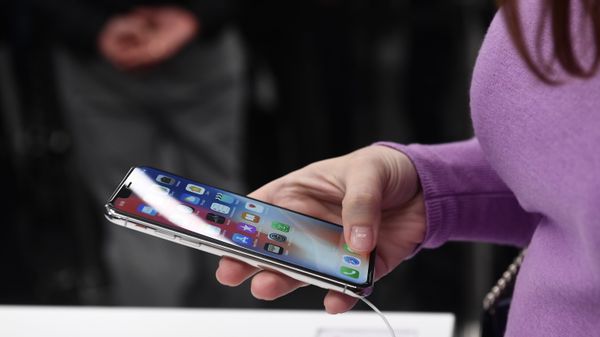 Покупательница рассматривает новый смартфон iPhone X в магазине re:Store в Москве