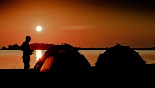 Отдыхающие в палатках на берегу Азовского моря в окрестностях поселка Курортное