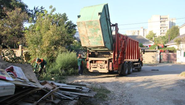 Сотрудники МУП Экоград за работой на одной из мусорных площадок в Симферополе