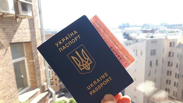 Гражданин Украины держит паспорт и патент на работу в РФ