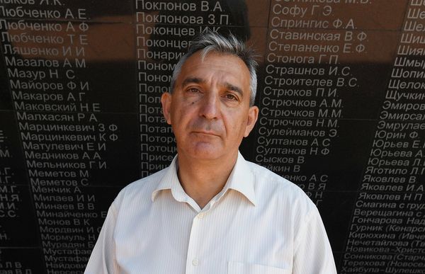 Директор мемориала Концлагерь Красный Сергей Жученко на фоне стены скорби мемориального комплекса жертвам фашистской оккупации Крыма 1941-1944 годов Концлагерь Красный