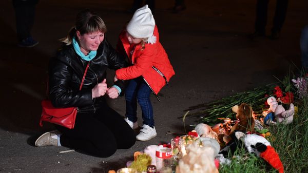 Женщина у народного мемориала на улице в Керчи, где в Керченском политехническом колледже произошли взрыв и стрельба