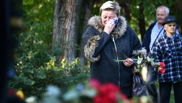 Люди несут цветы к народному мемориалу в Керчи в память о погибших в Керченском политехническом колледже, в котором произошли взрыв и стрельба