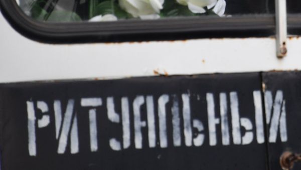 Мужчина в автомобиле ритуальной службы во время церемонии прощания с погибшими при нападении на Керченский политехнический колледж