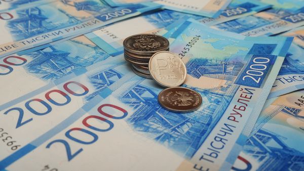 Банкноты номиналом 2000 рублей и монета 1 рубль с графическим обозначением символа рубля