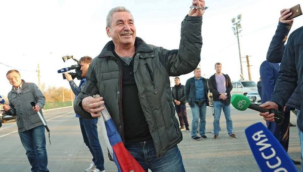 Моряк Норда во время процедуры обмена на экипаж украинского судна ЯМК-0041. В правой руке держит российский флаг, в левой - ключи от Норда