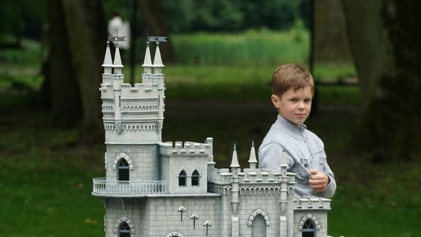 Посетитель рассматривает Ласточкино гнездо (Крым) в Южном парке Калининграда