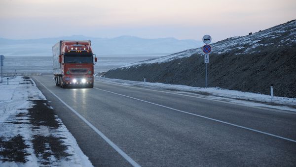 Грузовик едет по заснеженной трассе