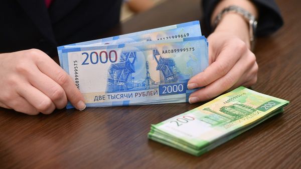 Сотрудница банка проводит денежные операции