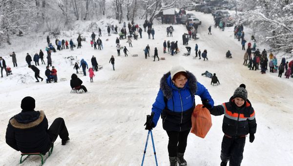 Люди катаются с горки на Ангарском перевале в Крыму