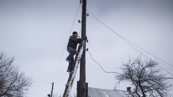 Мужчина ремонтирует линию электропередач