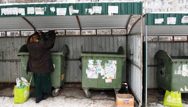 Женщина роется в мусорных контейнерах в Симферополе