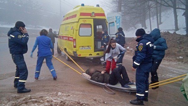 Сотрудники МЧС и скорой помощи оказывают помощь пострадавшему в крымских горах