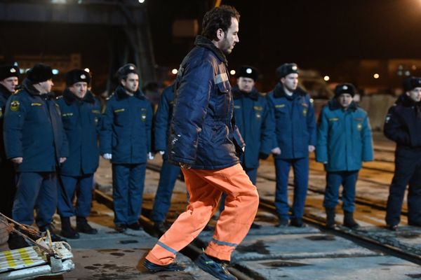 Иностранный моряк, спасенный с одного из горящих танкеров, сходит на берег с буксира морской спасательной службы Меркурий в торговом порту Керчи. 22 января 2019