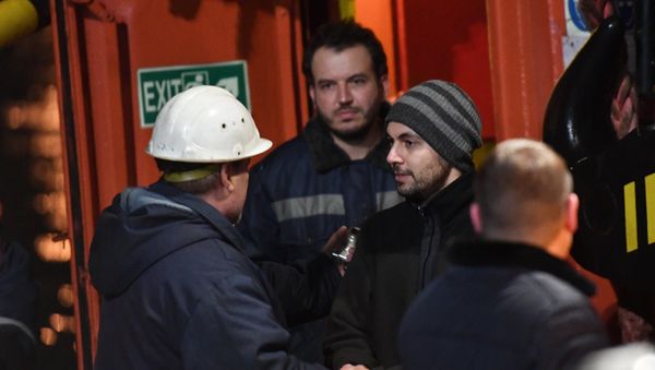 Иностранный моряк (справа), спасенный с одного из горящих танкеров, покидает буксир морской спасательной службы Меркурий в торговом порту Керчи. 22 января 2019