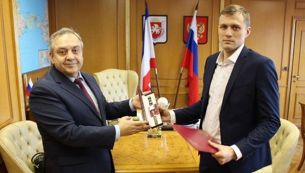 Постоянный представитель РК при президенте России Григорий Мурадов вручает Кириллу Салову наградные часы от главы Крыма
