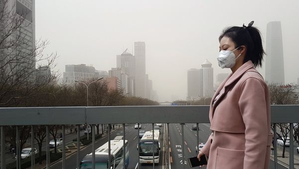Жительница Пекина в защитной маске во время смога. Архивное фото