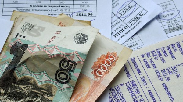Денежные купюры и квитанции за оплату коммунальных услуг