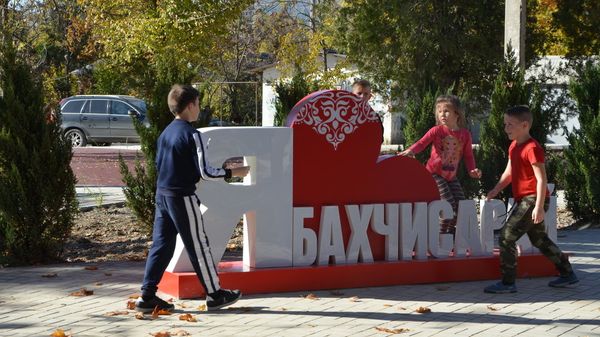 Дети играют в районе арт-объекта Я люблю Бахчисарай в парке по улице Фрунзе в Бахчисарае