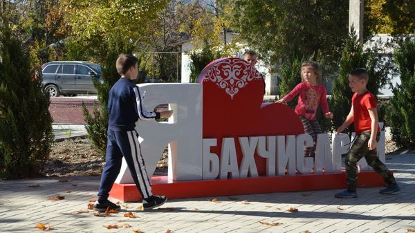Дети играют в районе арт-объекта Я люблю Бахчисарай в парке по улице Фрунзе в Бахчисарае