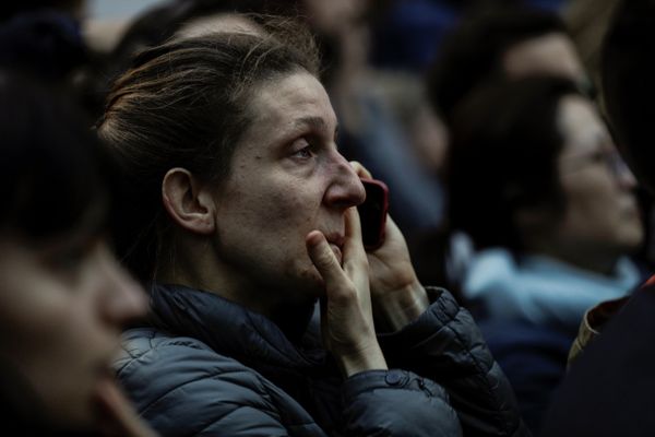 Женщина смотрит на горящий собор Парижской Богоматери