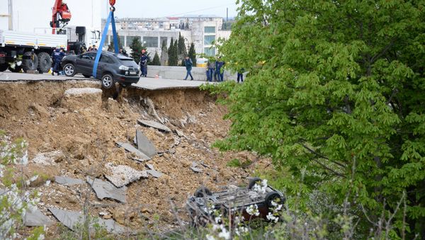 Машины, обвалившиеся вместе с парковкой возле многоквартирного дома в Севастополе