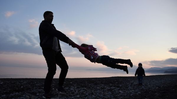 Отец играет с детьми в поселке Морское в Крыму