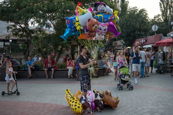 Отдыхающие на набережной Черного моря в Коктебеле Отдыхающие на набережной Черного моря в Коктебеле