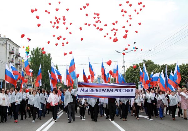 Участники шествия Лента времени с плакатом Мы выбираем Россию во время торжественных мероприятий, посвященных Дню Донецкой народной республики