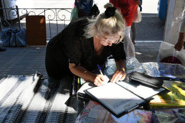 Женщина подписывает протокол, составленный на нее по факту ведения стихийной торговли в центре Симферополя Женщина подписывает протокол, составленный на нее по факту ведения стихийной торговли в центре Симферополя