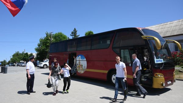 Автобус с гражданами из ДНР, которые приехали получать российские паспорта в отделение по вопросам миграции отдела МВД России по Ростовской области в селе Покровское