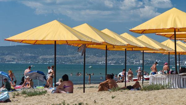 Отдыхающие на пляже на берегу Черного моря в поселке Береговое