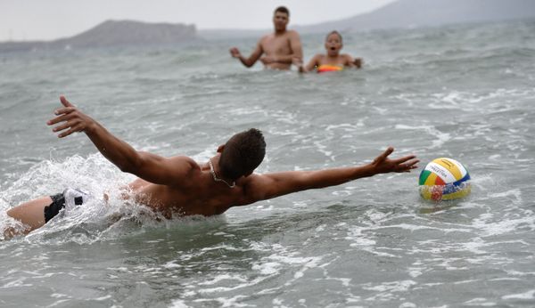 Отдыхающие играют в мяч на морском побережье в Крыму 