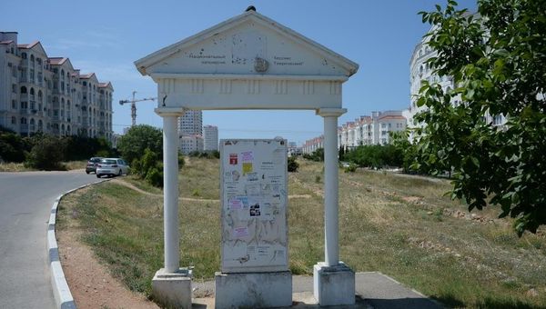 Потрепанный временем стенд перед античной дорогой
