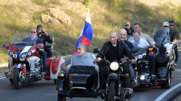 10 августа 2019. Президент РФ Владимир Путин участвует в организованном мотоклубом Ночные волки международном байк-шоу Тень Вавилона в Севастополе за рулем мотоцикла Урал с коляской. Третий справа - глава Республики Крым, председатель Совета министров РК Сергей Аксёнов. Справа на первом плане - временно исполняющий обязанности губернатора Севастополя Михаил Развозжаев.