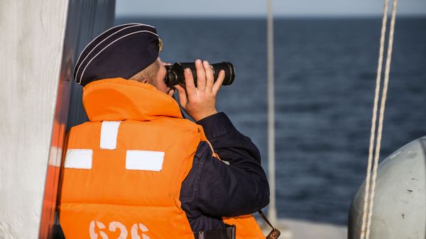 Моряк смотрит в бинокль на борту малого ракетного корабля (МРК) проекта 21631 Орехово-Зуево на учениях Черноморского флота и ЮВО в Крыму