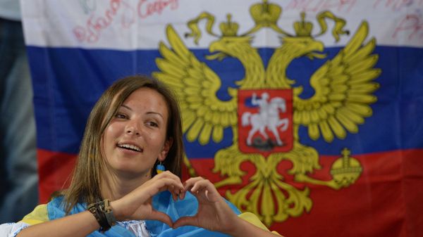 Девушка с флагом Украины на фоне флага России
