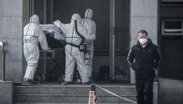 Медперсонал доставляет зараженного коронавирусом пациента в одну из больниц города Ухань в Китае