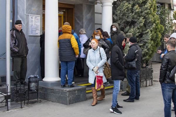 В помещение банка Россия пускают по-одному. Но народ стоит в очереди снаружи.  Очень тесной очереди. 