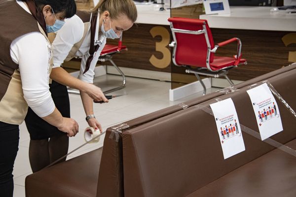 В МФЦ на ул. Мате Залки посетители пока есть, но их не много. Работники всеми силами стараются ограничить количество людей в зале - клеят специальные объявления о дистанции между посетителями и даже самодельные ограничители.