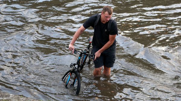 Велосипедист на подтопленной улице Велосипедист на подтопленной улице